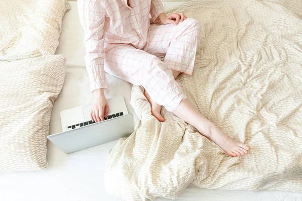 Mobil Ofis evde. Evde pijamalı genç bir kadın dizüstü bilgisayar kullanarak çalışıyor. Yaşam tarzı kızı içeride ders çalışıyor. Serbest ticaret karantina kavramı