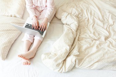 Mobil Ofis evde. Evde pijamalı genç bir kadın dizüstü bilgisayar kullanarak çalışıyor. Yaşam tarzı kızı içeride ders çalışıyor. Serbest ticaret karantina kavramı