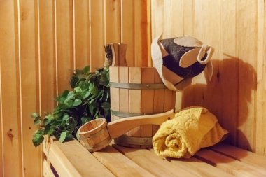 İçişleri, geleneksel sauna aksesuarları, süpürge kepçesi kepçeli şapka havlusuyla Finlandiya sauna sauna saunası detaylarını anlatıyor. Geleneksel eski Rus hamamı SPA konsepti. Rahatlayın köy banyosu konsepti