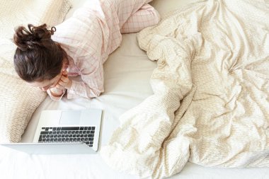 Mobil Ofis evde. Evde pijamalı genç bir kadın dizüstü bilgisayar kullanarak çalışıyor. Yaşam tarzı kızı içeride ders çalışıyor. Serbest ticaret karantina kavramı