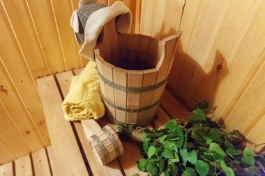 İçişleri, geleneksel sauna aksesuarları, süpürge kepçesi kepçeli şapka havlusuyla Finlandiya sauna sauna saunası detaylarını anlatıyor. Geleneksel eski Rus hamamı SPA konsepti. Rahatlayın köy banyosu konsepti