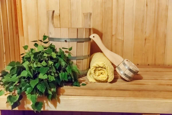Interior details Finnish sauna steam room with traditional sauna accessories basin birch broom scoop towel. Traditional old Russian bathhouse SPA Concept. Relax country village bath concept