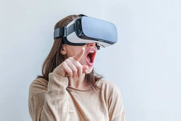 Sonríe mujer joven usando realidad virtual gafas VR casco auriculares sobre fondo blanco. Smartphone con gafas de realidad virtual. Tecnología, simulación, alta tecnología, concepto de videojuego. — Foto de Stock