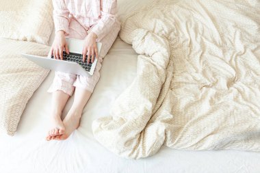 Mobil Ofis evde. Evde pijamalı genç bir kadın dizüstü bilgisayar kullanarak çalışıyor. Yaşam tarzı kızı içeride ders çalışıyor. Serbest ticaret karantina kavramı
