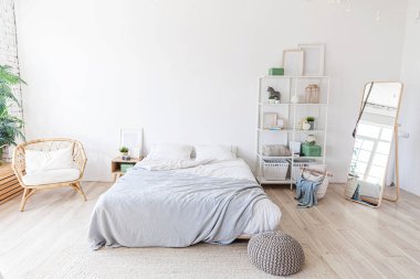 Evin içinde şık bir çatı katı var. Geniş duvarları, geniş pencereleri, büyük yatağı olan geniş bir tasarım dairesi. Minimalist İskandinav tarzında zarif mobilyalarla temiz modern dekorasyon.