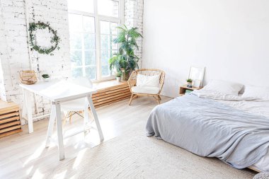 Evin içinde şık bir çatı katı var. Geniş duvarları, geniş pencereleri, büyük yatağı olan geniş bir tasarım dairesi. Minimalist İskandinav tarzında zarif mobilyalarla temiz modern dekorasyon.