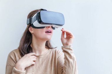 Beyaz arka planda sanal gerçeklik gözlüğü başlığı takan genç kadın gülümse. Sanal gerçeklik gözlüğü takan akıllı telefon. Teknoloji, simülasyon, yüksek teknoloji, video oyunu konsepti
