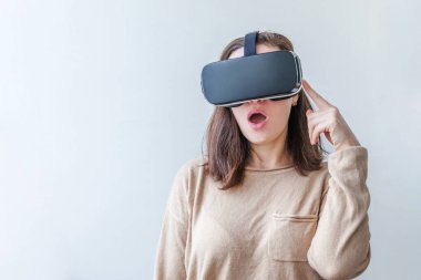 Beyaz arka planda sanal gerçeklik gözlüğü başlığı takan genç kadın gülümse. Sanal gerçeklik gözlüğü takan akıllı telefon. Teknoloji, simülasyon, yüksek teknoloji, video oyunu konsepti
