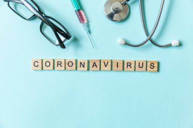 Mavi pastel arka planda Coronavirus şırınga gözlüğü ve steteskop ifadesi. Roman Coronavirus 2019-nCoV MERS-Cov Covid-19 Orta Doğu Solunum Sendromu Coronavirus virüs aşısı konsepti
