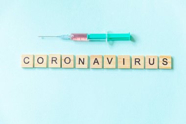 Yazılı ifade Coronavirus ve mavi pastel arka planda şırınga. Roman Coronavirus 2019-nCoV MERS-Cov Covid-19 Orta Doğu Solunum Sendromu Coronavirus virüs aşısı konsepti