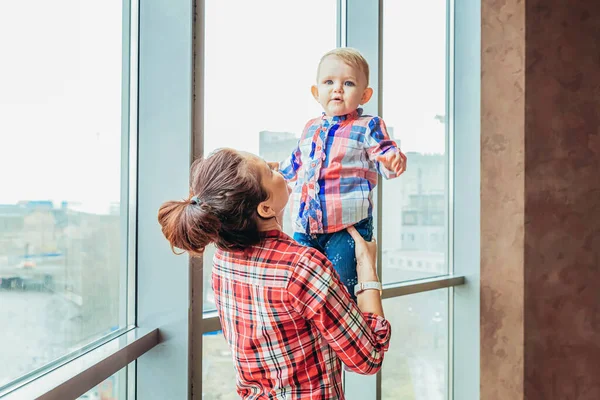 Stay Home Stay Safe. Young mother holding her child. Woman and infant little girl relaxing in white bedroom near windiow indoors. Happy family at home. Young mom playing whith her daughter. — Stock Photo, Image