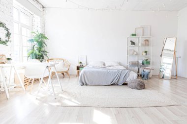 Evin içinde şık bir çatı katı var. Geniş duvarları, geniş pencereleri, büyük yatağı olan geniş bir tasarım dairesi. Minimalist İskandinav tarzında zarif mobilyalarla temiz modern dekorasyon.