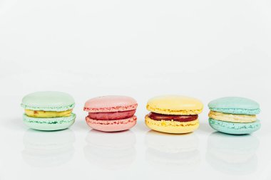 Tatlı badem renginde pastel pembe mavi yeşil badem kurabiyesi ya da beyaz arka planda izole edilmiş badem kurabiyesi. Fransız kurabiyesi. Asgari gıda fırını konsepti. Boşluğu kopyala