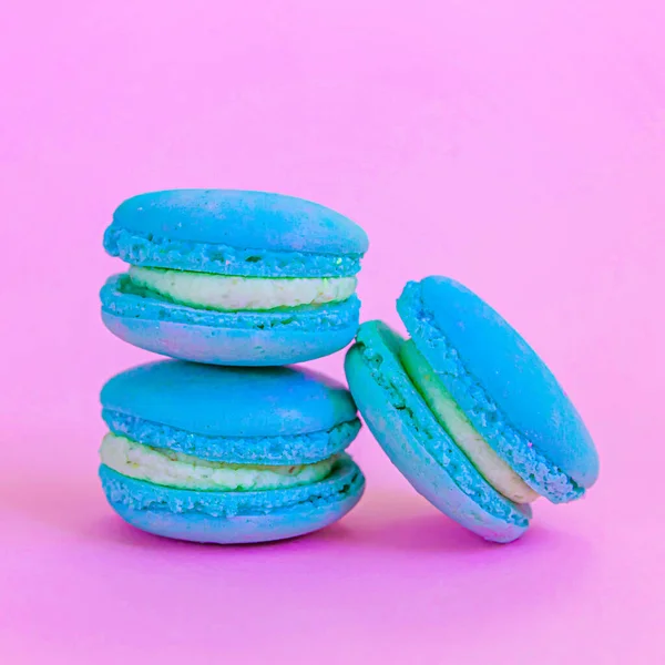 Sweet almond colorful unicorn blue macaron or macaroon dessert cake isolated on trendy pink pastel background. French sweet cookie. Minimal food bakery concept. Copy space