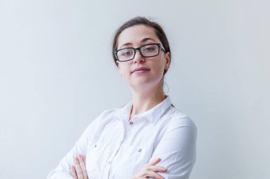 Güzel mutlu kız gülümsüyor. Güzel, basit bir portre. Beyaz arka planda gözlüklü, gülümseyen esmer kadın. Olumlu insani duygu yüz ifadesi vücut dili. Boşluğu kopyala.