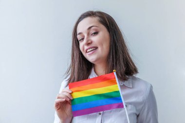Beyaz arka planda izole edilmiş LGBT gökkuşağı bayraklı güzel beyaz lezbiyen kız mutlu ve heyecanlı görünüyor. Genç kadın Gay Gurur portresi. lgbtq topluluk kavramı için eşit haklar