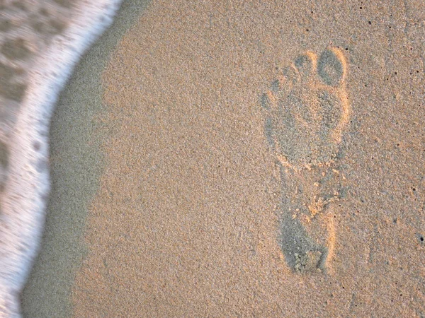 Footprint on the sand with sea wave — Stock Photo, Image