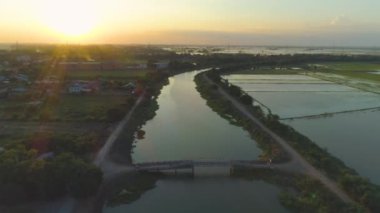 Akşam atmosferinde kırsal yaşam, yukarıdan kasabayı ve pirinç tarlalarını görebilirsin..