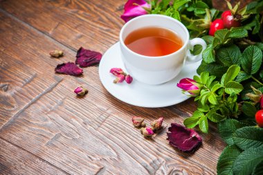 Ahşap masa üzerinde bir dogrose ile sağlıklı çay