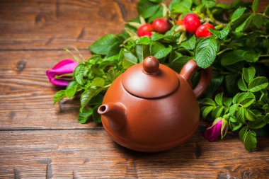 Ahşap masa üzerinde bir dogrose ile sağlıklı çay