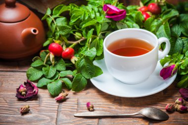 Ahşap masa üzerinde bir dogrose ile sağlıklı çay