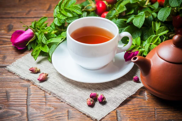 Gesunder Tee mit Heckenrose auf Holztisch — Stockfoto