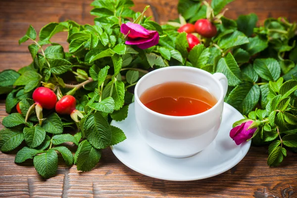 Hälsosamt te med en dogrose på träbord — Stockfoto