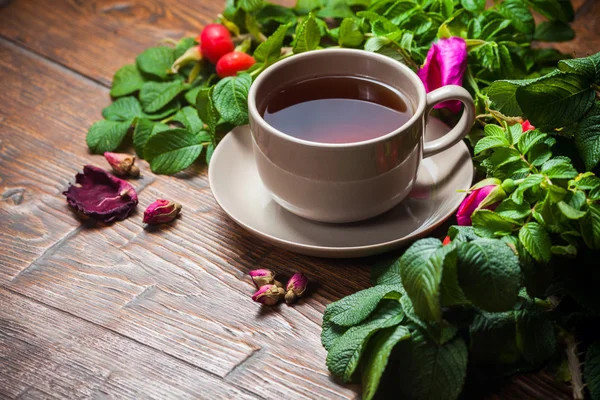 Healthy tea with a dogrose on wooden table — Stock Photo, Image
