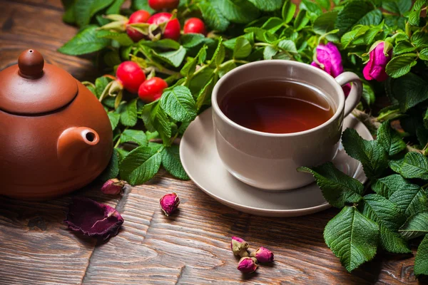 Gesunder Tee mit Heckenrose auf Holztisch — Stockfoto