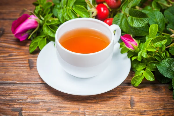 Gezonde thee met een dogrose op houten tafel — Stockfoto