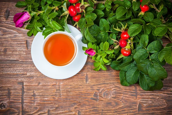 Hälsosamt te med en dogrose på träbord — Stockfoto