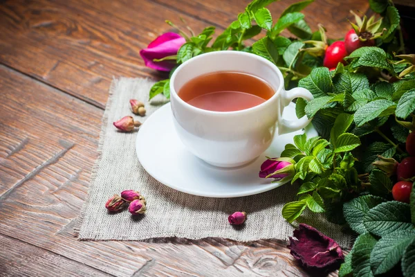 Healthy tea with a dogrose on wooden table — Stock Photo, Image