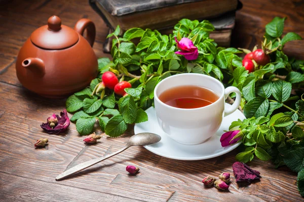 Gesunder Tee mit Heckenrose auf Holztisch — Stockfoto