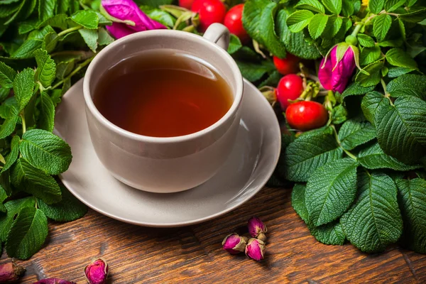 Té saludable con un escaramujo en la mesa de madera —  Fotos de Stock