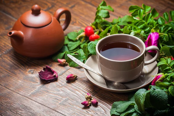 Υγιή τσάι με ένα τριαντάφυλλο στο ξύλινο τραπέζι — Φωτογραφία Αρχείου