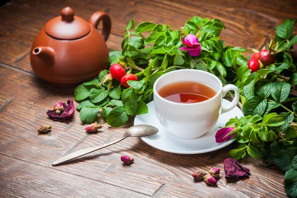 Gesunder Tee mit Heckenrose auf Holztisch — Stockfoto