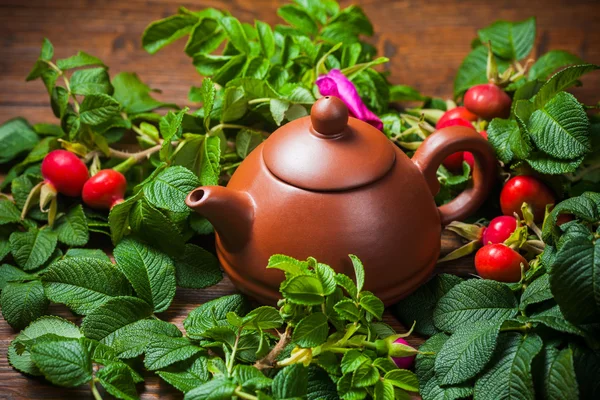 Zdravý čaj s dogrose na dřevěný stůl — Stock fotografie