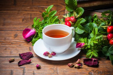 Ahşap masa üzerinde bir dogrose ile sağlıklı çay