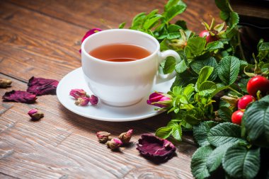 Ahşap masa üzerinde bir dogrose ile sağlıklı çay