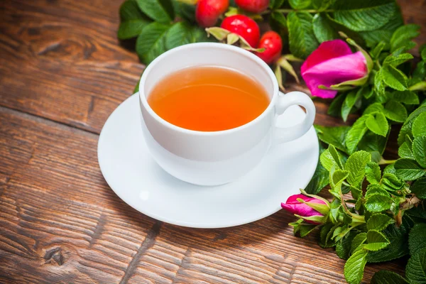 Tè sano con un dogrose sul tavolo di legno — Foto Stock