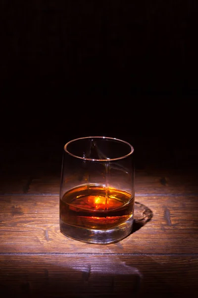 Glass of whiskey on wooden table — Stock Photo, Image