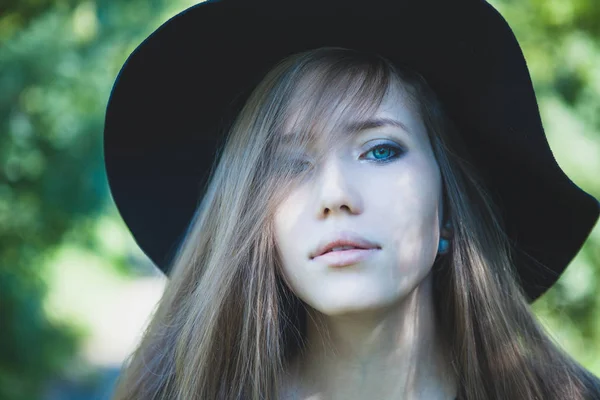 Vrouw met blauwe ogen in zwarte hoed. Koude Toon. — Stockfoto