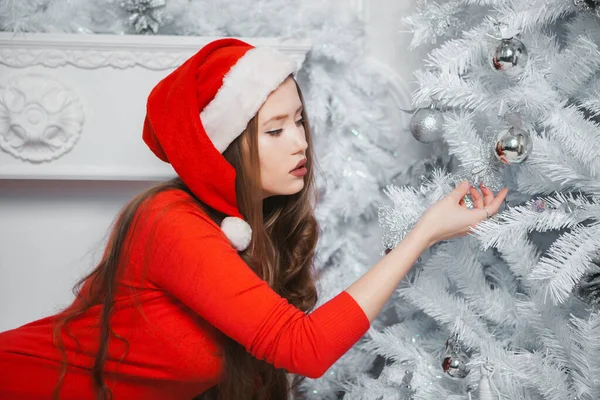 Julkvinnan i Santa Hat. Glad leende flicka firar nyår hemma. — Stockfoto