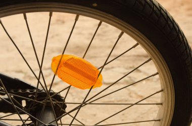 Turuncu reflektör ve tekerlek teli gösteren bir bisiklet tekerleği yakın çekim