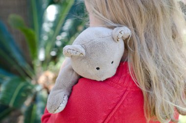 Küçük kız onu teddy sıkıca sarılma