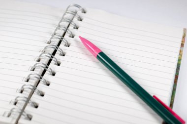 Boş sayfa spiral defter kalem ile bağlı.