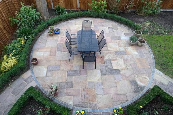 Un patio giardino circolare con tavolo e sedie — Foto Stock