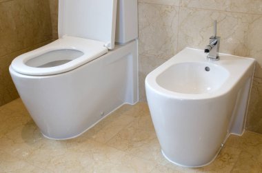 Tuvalet ve bir mermer döşeli banyo bide
