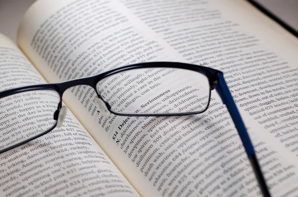 Brýle v knize, zvýraznění vážnosti slovo — Stock fotografie