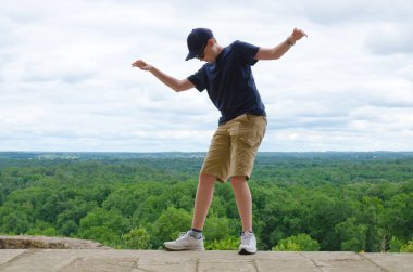 Boy balancing on the edge of a drop - danger concept